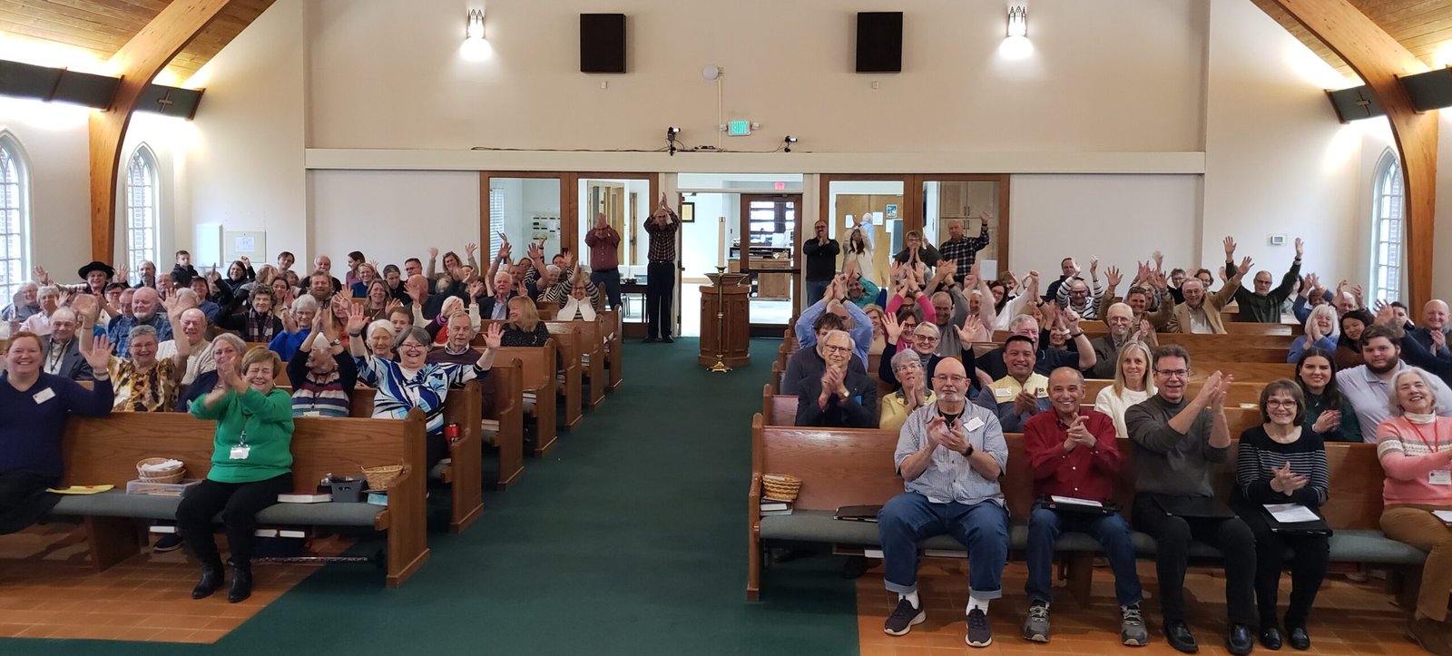 GSLC members in sanctuary smiling and applauding